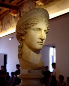 Juno Ludovisi marble bust with wavy hair and a composed expression on a decorated pedestal.