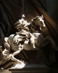 The Vision of Constantine, a white marble equestrian statue lit by sunlight inside an ornate niche.