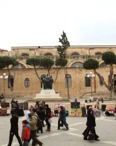Great Siege Monument with three bronze figures on a white tiered base in front of a stone building