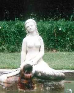Mermaid Fountain statue of a mermaid sitting on a stone structure with water flowing into a basin