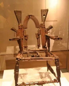 Throne of Weapons sculpture made from rusted gun parts and firearm components.