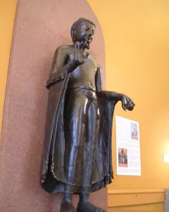 Sultanganj Buddha sculpture with raised right hand and outstretched left arm on a raised platform.