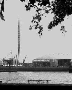 The Skylon, a tall slender pointed framework structure, rises against a bright sky.
