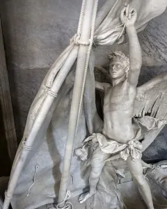 Angelo Nocchiero, a winged marble angel standing in a boat and holding ropes beside a mast and furled sails.