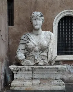 Madama Lucrezia, a weathered stone statue of a draped woman with an eroded face on a pedestal.