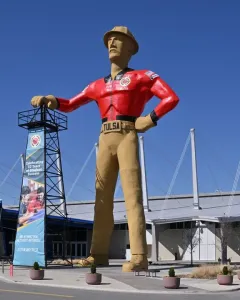 The Golden Driller statue stands with one hand on an oil derrick and one hand on his hip in Tulsa.