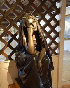La Douleur bronze sculpture of a seated figure resting its chin on one hand