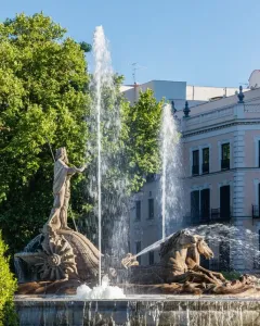 The Fountain of Neptune in Madrid with Neptune standing on a shell, flanked by two sea-horse figures and surrounded by jets of water.