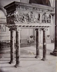 The Resurrection Pulpit by Donatello, a bronze pulpit with detailed relief scenes on four marble columns inside a church.