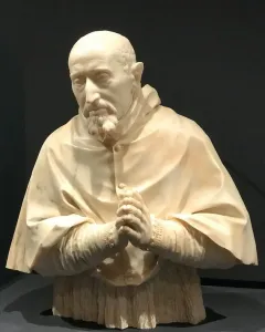 Marble bust of Cardinal Roberto Bellarmine showing a bearded man in a hooded robe with clasped hands.