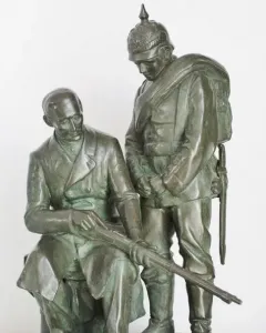 Dreyse Monument showing a seated man holding a rifle beside a standing soldier in a spiked helmet.