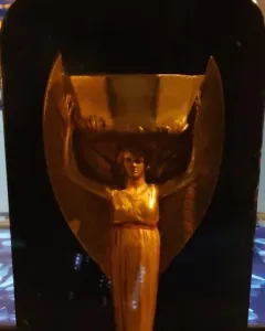 Jules Rimet Trophy replica with a winged female figure holding a cup overhead on a dark base.