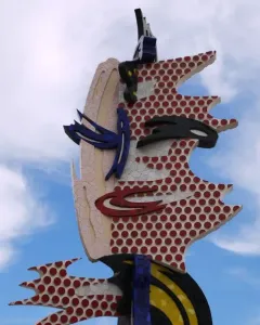 The Face of Barcelona sculpture with a stylized face in cracked mosaic and red polka dots.