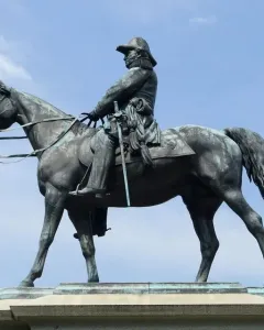 Winfield Scott equestrian statue in bronze against a blue sky with scattered clouds.
