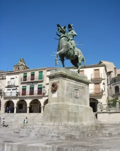 Francisco Pizarro equestrian statue on a stone pedestal in a sunlit square.