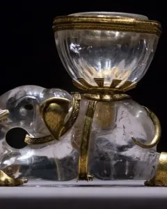 Crystal elephant with gold accents carrying a clear salt cellar on its back.