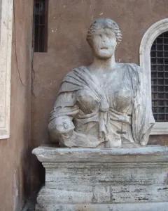 Madama Lucrezia, a weathered stone statue of a draped woman with an eroded face on a pedestal.