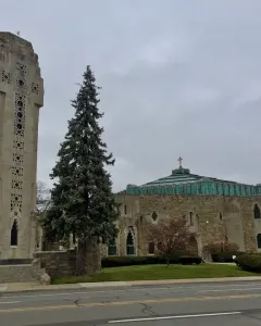 National Shrine of the Little Flower with its stone crucifixion tower beside the sanctuary and green domed roof.