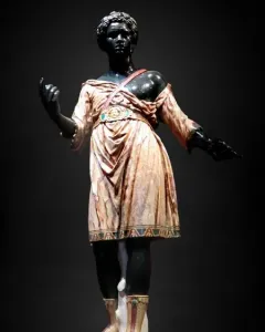 Moor of Borghese statue showing a dark-skinned figure in a patterned tunic and boots with one arm raised.