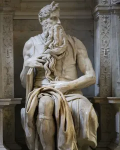 Michelangelo\'s Moses, a seated marble statue of a bearded man with horns holding tablets under his arm.