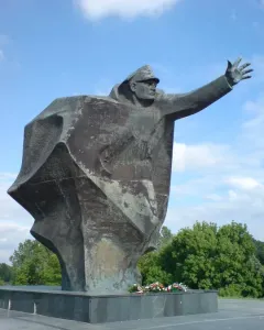 Kościuszkowców Memorial bronze statue of a uniformed figure with one arm outstretched on a stepped base