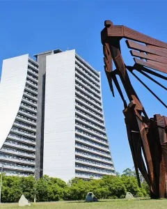 Monument to the Azoreans, a rust-colored abstract metal sculpture with human figures and a sweeping ship-like form against the sky.
