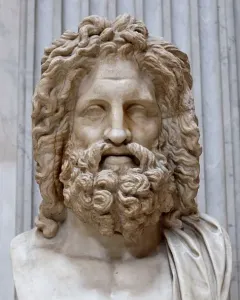 Zeus of Otricoli marble bust with curly hair and a beard on an inscribed pedestal.