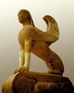 The Sphinx of Naxos stone sculpture with a woman\'s head, feathered wings, and a lion-like body on a decorative base.