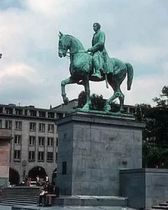 Albert I equestrian statue on a stone pedestal in a public square, with buildings and steps in the background.