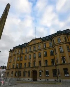The Obelisk at Slottsbacken rises from a cobblestone plaza with people gathered around it.