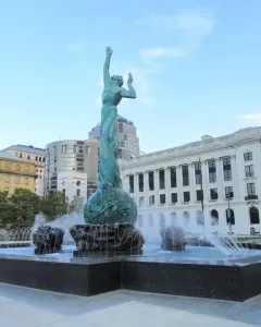 The Fountain of Eternal Life bronze sculpture rises from a large basin with water jets spraying around it.