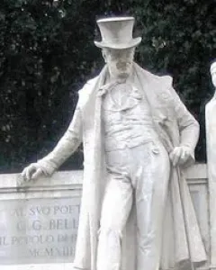 Monument to Giuseppe Gioachino Belli showing a stone statue of a man in a top hat and long coat leaning on a plinth with a cane.