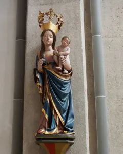 Inkpot Madonna statue of a crowned woman holding a child, with an inkpot and quill, mounted on a decorative bracket.
