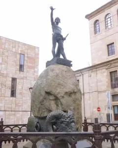 Monument to Viriato, a dark metal warrior sculpture on a large boulder behind an iron fence.