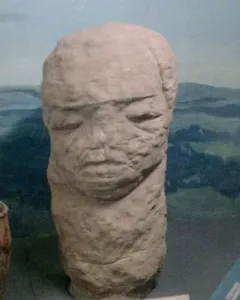 Škloŭ Idol, a weathered stone sculpture with a stylized human-like face.