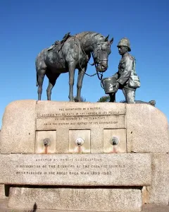 The Horse Memorial shows a saddled horse beside a kneeling soldier holding a bucket on a stone plinth with inscriptions.
