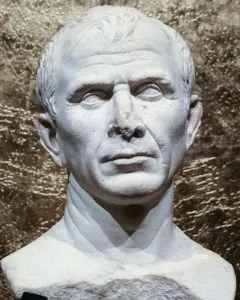 Weathered white marble bust of an older man with short wavy hair and a serious expression.
