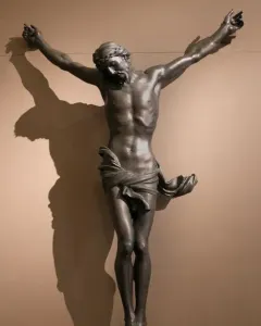 Bernini\'s Corpus, a dark bronze crucified Christ with outstretched arms, bowed head, and crown of thorns.