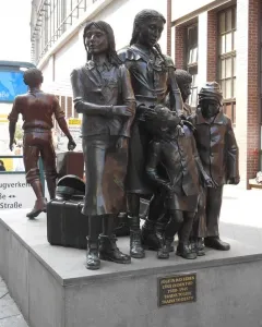 Trains to Life – Trains to Death monument showing several bronze children on a stone base with a plaque.