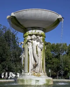 Dupont Circle Fountain with cascading water, classical figures carved on the central shaft, and green-stained marble.