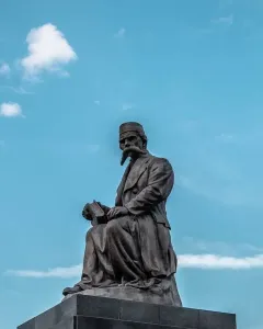 Vuk Karadžić Monument showing a bronze seated figure holding an open book on a stone pedestal.