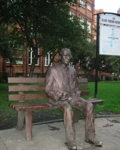 Alan Turing Memorial bronze statue seated on a park bench holding an apple.