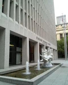 The Quest, a white sculptural fountain with intertwined human figures in a rectangular pool.