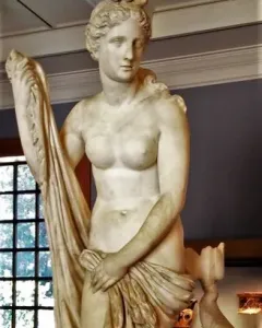 Mazarin Venus, a carved stone statue of a standing female figure holding draped cloth, with a dolphin-like creature at her feet.