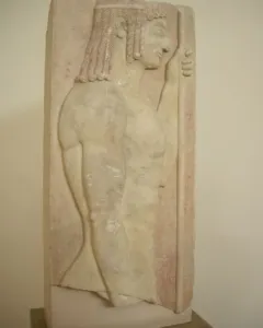 Grave stele relief of a youthful male figure in profile holding a staff against a red background.
