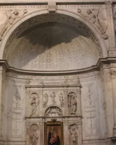 White marble statue of Saint Peter in the Piccolomini Altar at Siena Cathedral, shown in a twisting pose with a book held in his left arm.