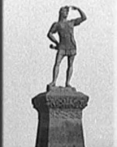 Leif Erikson statue standing on a decorated pedestal with one hand shading his eyes and the other on his hip.