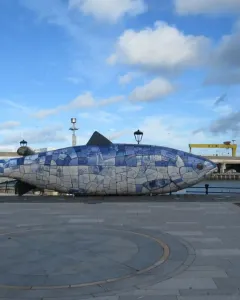 The Big Fish mosaic sculpture on a waterfront promenade beside the river in Belfast.