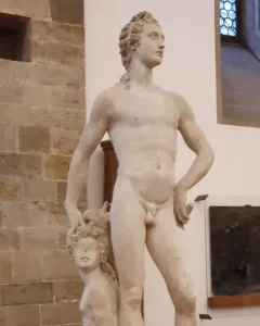Marble sculpture of Apollo and Hyacinth showing a standing nude male figure and a kneeling figure beside him.