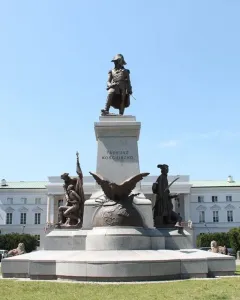 Tadeusz Kościuszko Monument with a bronze figure on a pedestal, flanked by additional sculptures including an eagle in a grassy park.